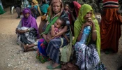 People wait outside a distribution point to receive aid rations in Oromia Region, Ethiopia, in February 2018.